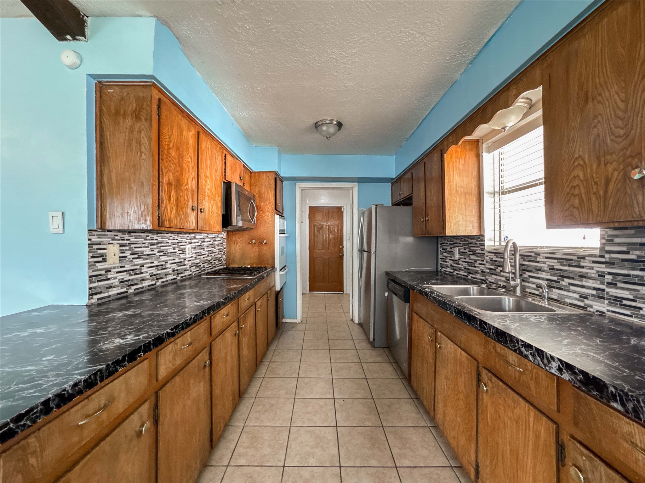 4522 Sage Circle Baytown, TX 77521 - Photo 11 of 33 a large kitchen with stainless steel appliances granite countertop a stove a sink and a microwave