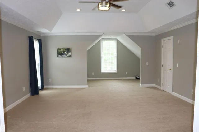 an empty room with windows and ceiling fan