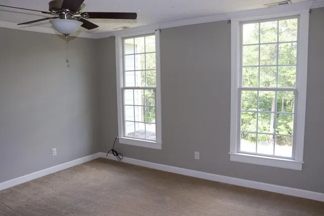 an empty room with a window and a fan