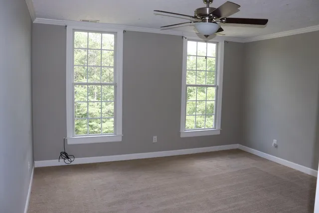 an empty room with a window and a fan