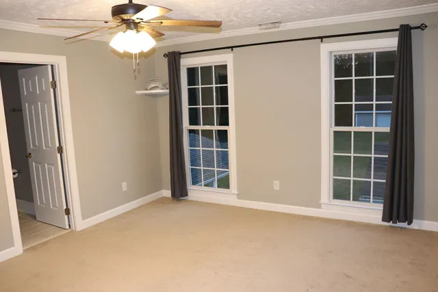 an empty room with windows and cabinet