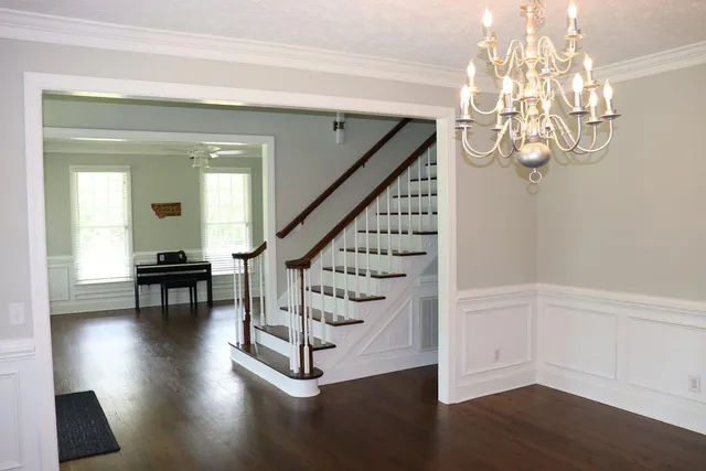 a view of a livingroom with wooden floor and stairs