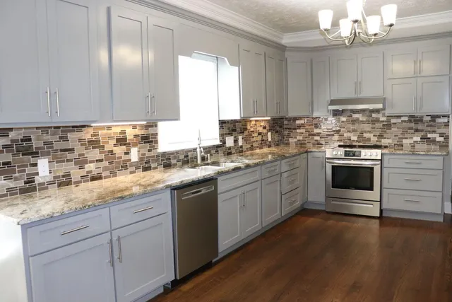 a kitchen with cabinets wooden floor and stainless steel appliances