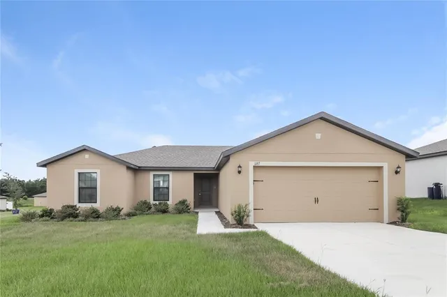 a view of a house with a yard and garage