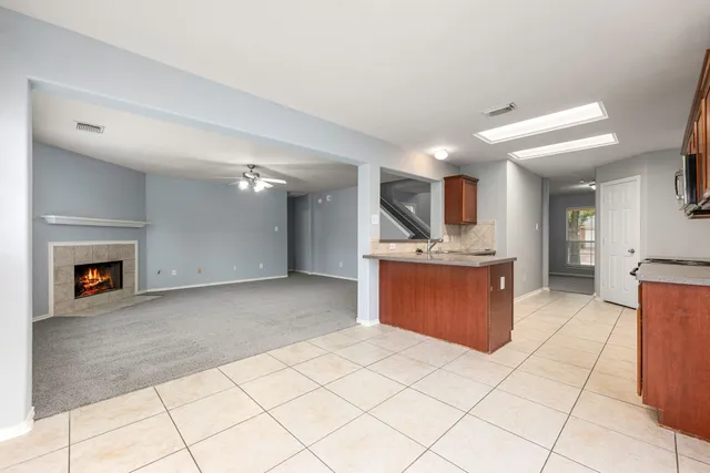 a kitchen with stainless steel appliances granite countertop a stove top oven a sink dishwasher a dining table and chairs with wooden floor