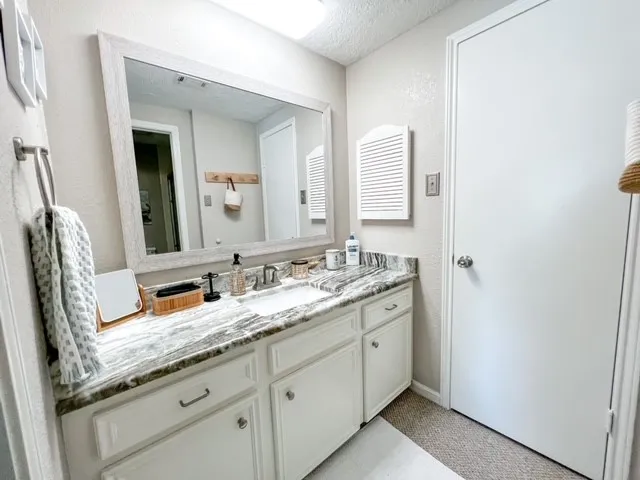a bathroom with a granite countertop sink and a mirror