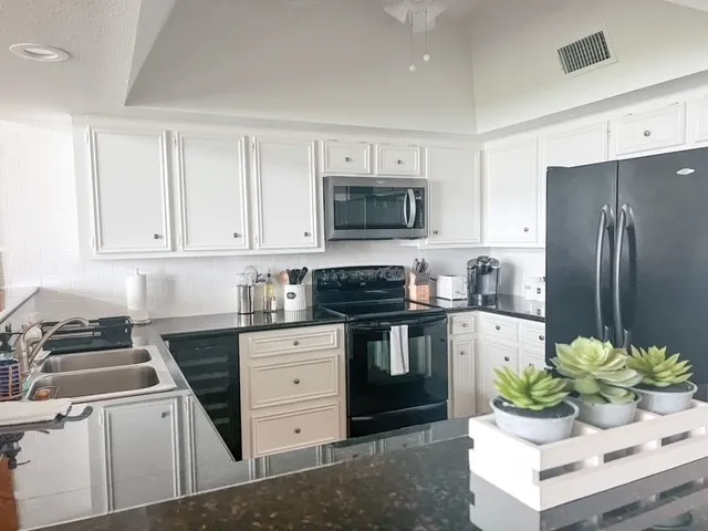 a kitchen with stainless steel appliances a stove a sink and a refrigerator