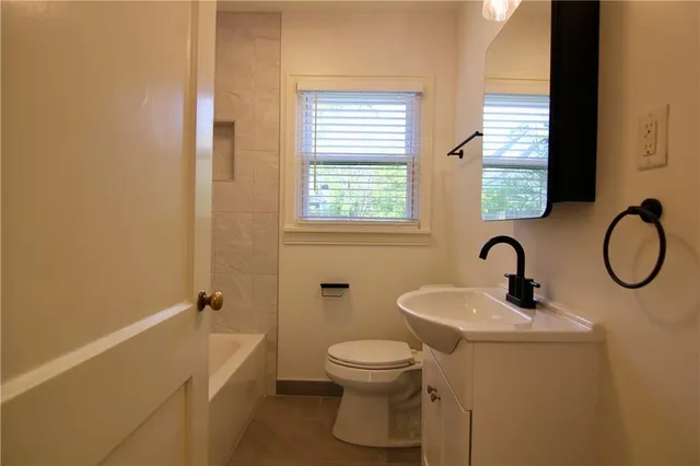 a bathroom with a toilet sink and mirror