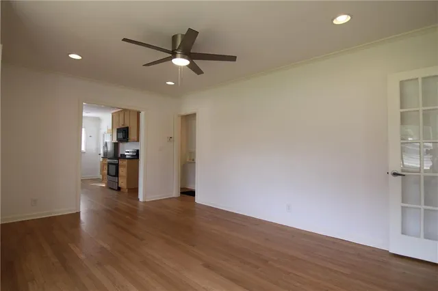 a view of a kitchen with wooden floor and a ceiling fan