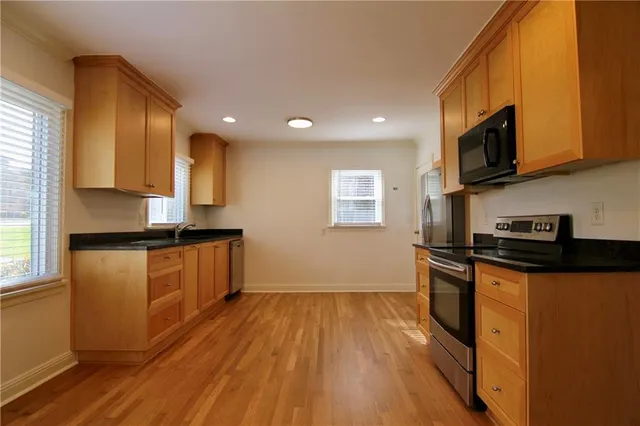 a kitchen with stainless steel appliances granite countertop a stove a sink and a refrigerator