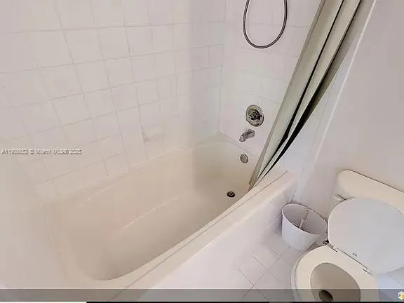 a view of a kitchen with refrigerator and white cabinets