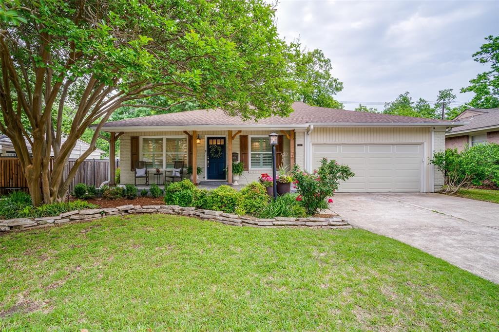 a front view of a house with a yard and potted plants