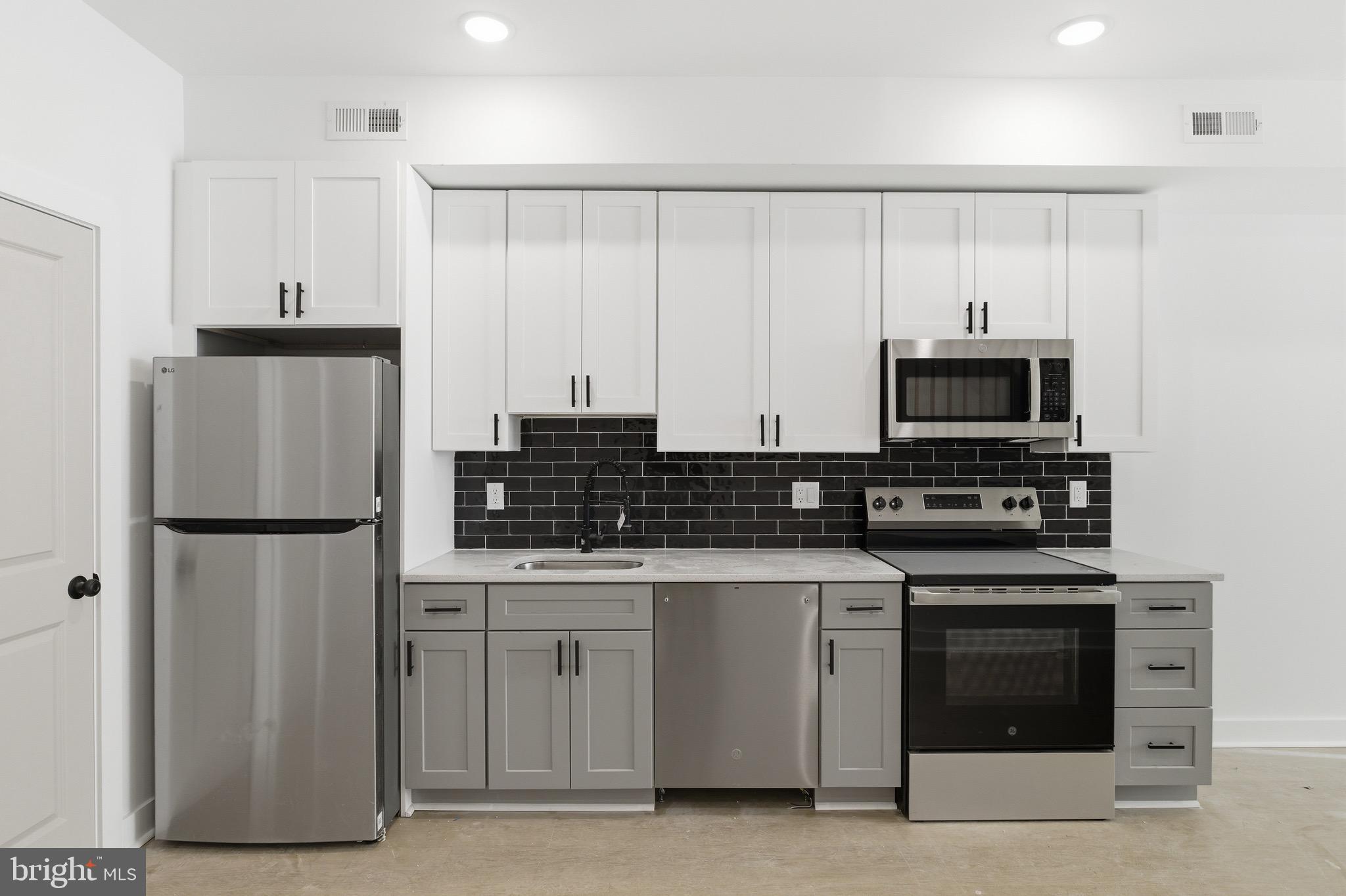 2116 North 7th Street, Unit 2 Philadelphia, PA 19122 - Photo 13 of 21 a kitchen with white cabinets and stainless steel appliances