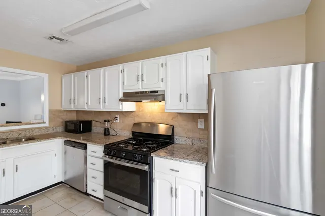 a kitchen with a white cabinets and white appliances
