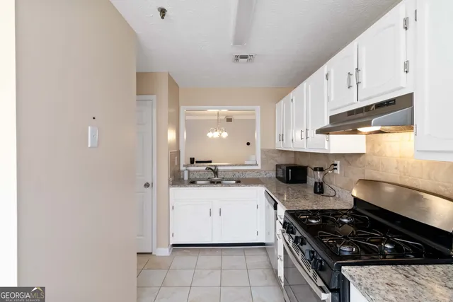 a kitchen with stainless steel appliances a sink a stove and cabinets
