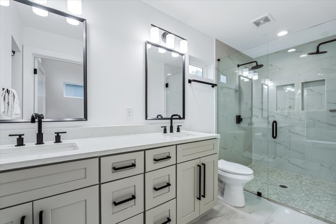 6300 Santos Street, Unit 3 Austin, TX 78741 - Photo 21 of 32 a bathroom with a toilet a sink a shower and a mirror