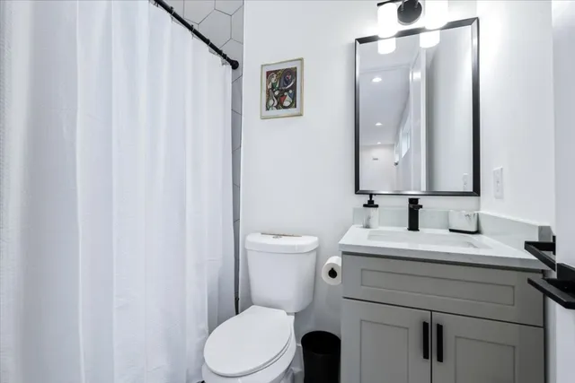 a bathroom with a toilet a sink and a mirror
