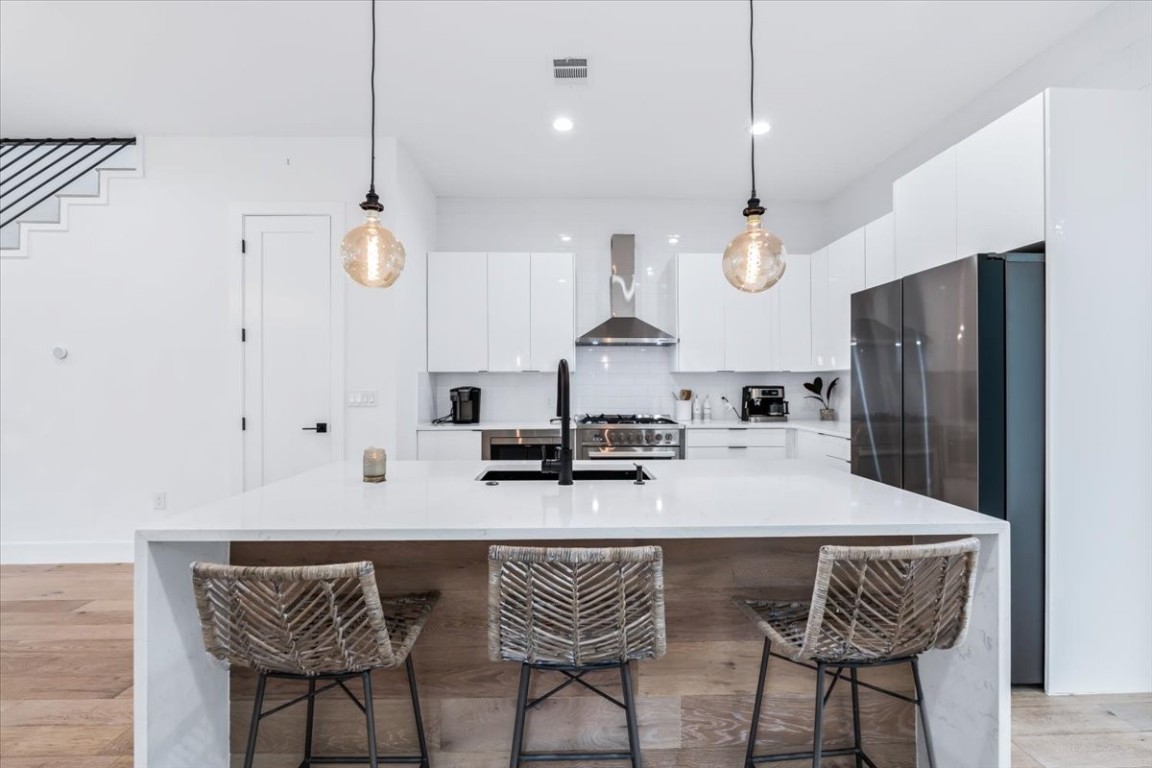 6300 Santos Street, Unit 3 Austin, TX 78741 - Photo 9 of 32 a kitchen with stainless steel appliances kitchen island granite countertop a table chairs and a refrigerator
