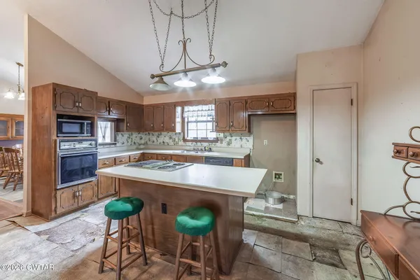 a living room with stainless steel appliances kitchen island granite countertop furniture and a kitchen view