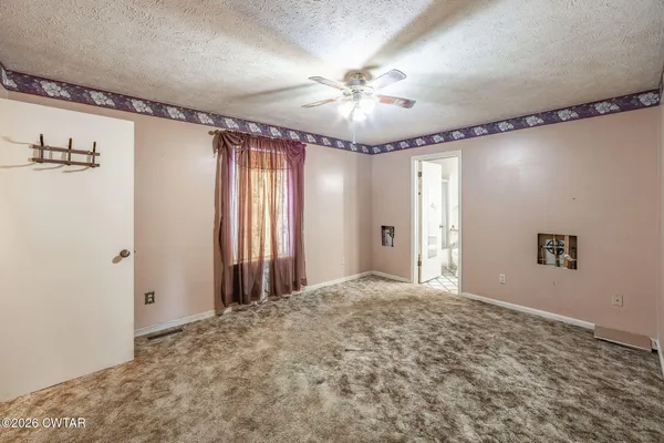 a view of a livingroom with a ceiling fan and wooden floor