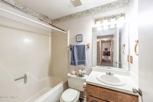 a view of a hallway with a chandelier fan and closet