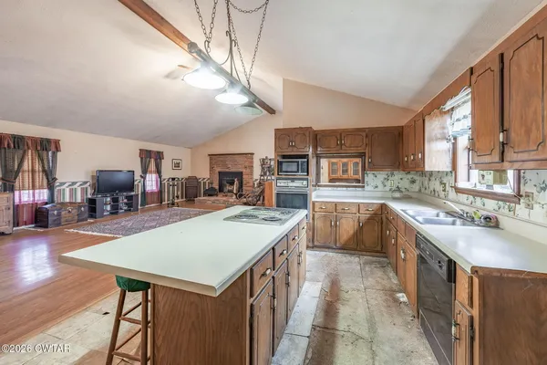 a kitchen with stainless steel appliances granite countertop a sink a stove and a refrigerator