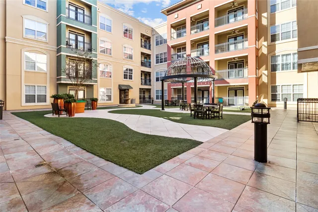 a front view of a building with garden and plants