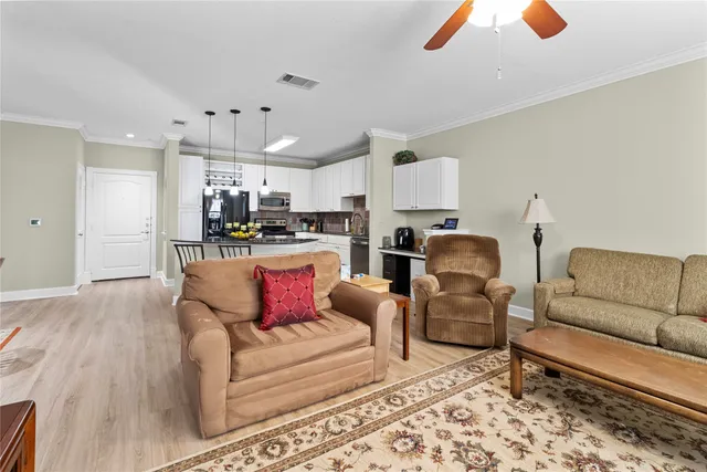 a living room with furniture and kitchen view