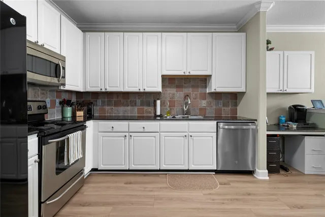 a kitchen with stainless steel appliances granite countertop a stove a sink and a microwave
