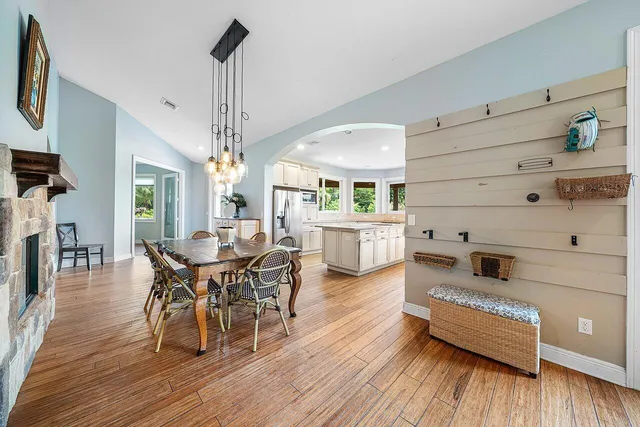 a kitchen with stainless steel appliances granite countertop a refrigerator a sink dishwasher a stove and white countertops with wooden floor