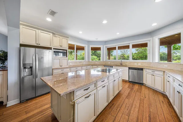 a kitchen with stainless steel appliances kitchen island granite countertop a stove and a refrigerator