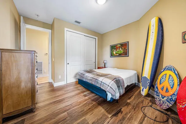 a bedroom with a bed and wooden floor