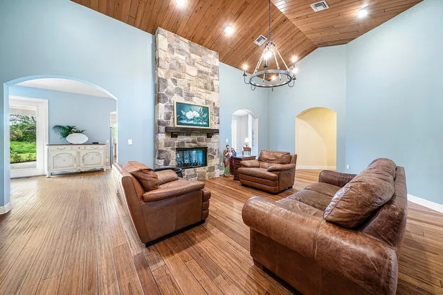 a living room with furniture a chandelier and a fireplace