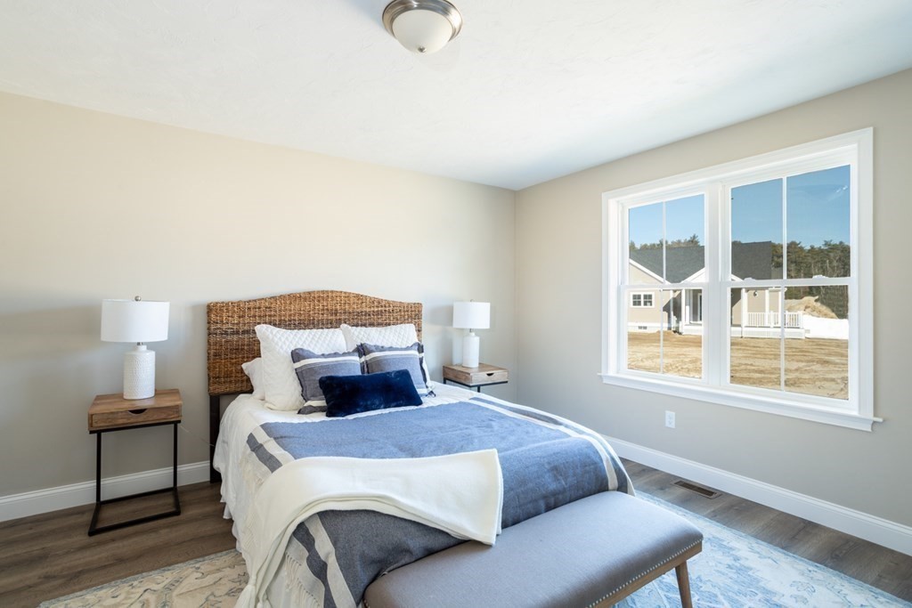 7 Hayley Circle, Unit 34 Rochester, MA 02770 - Photo 9 of 12 a bedroom with a bed and wooden floor
