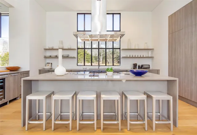 a kitchen with white cabinets and chairs