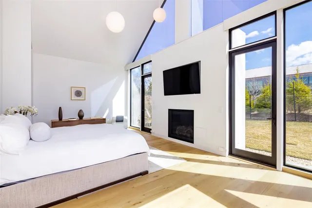 a spacious bedroom with a bed and a flat screen tv