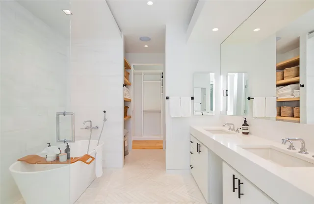 a spacious bathroom with a double vanity sink tub and mirror
