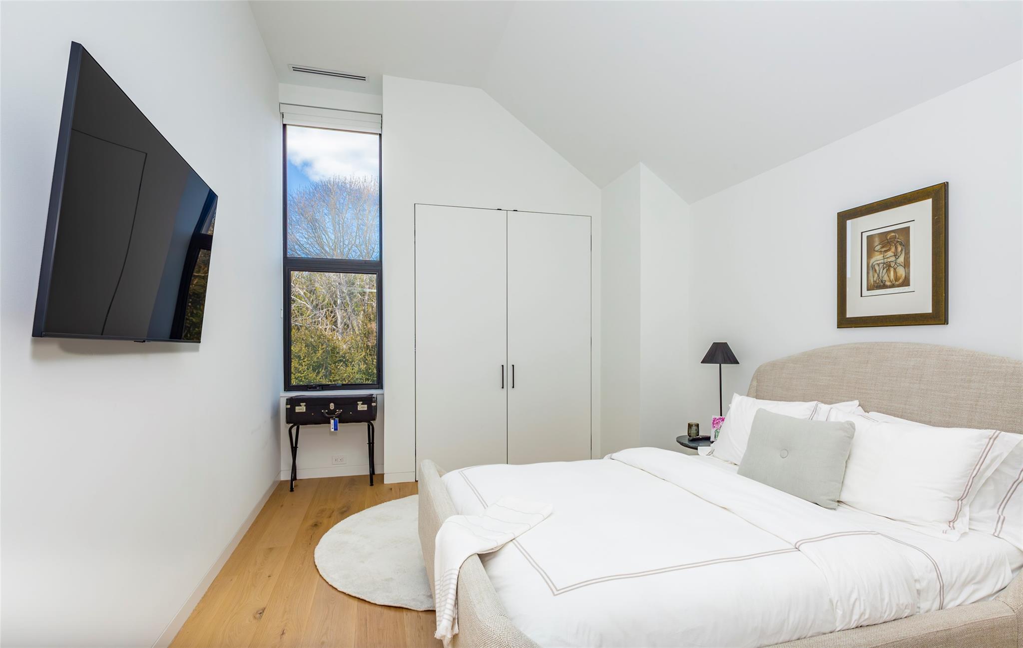 179 Montauk Highway East Hampton, NY 11937 - Photo 31 of 47 a bedroom with a bed and a flat screen tv