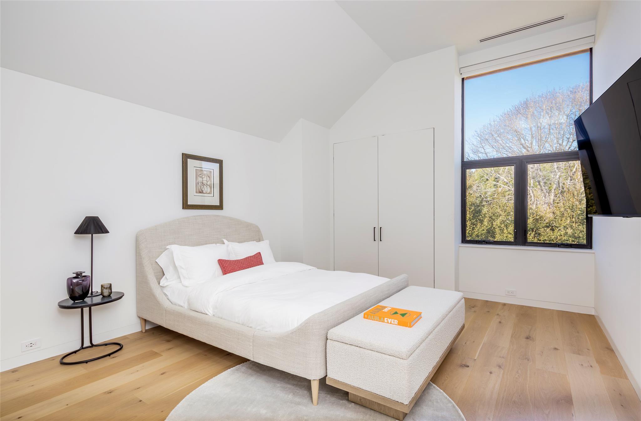 179 Montauk Highway East Hampton, NY 11937 - Photo 34 of 47 a bedroom with a bed and a lamp on table