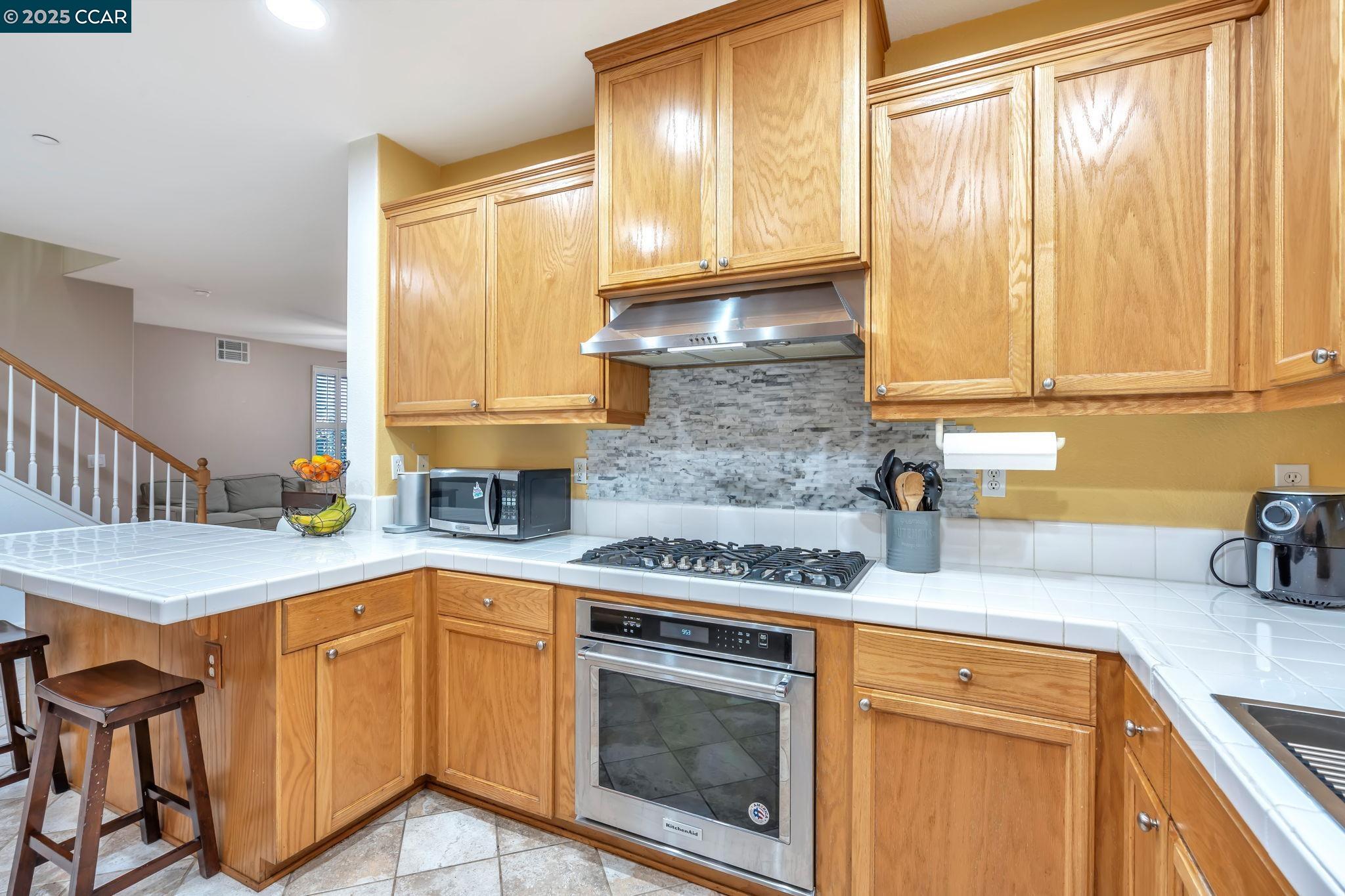 2036 Serra Lane Hercules, CA 94547 - Photo 17 of 60 a kitchen with stainless steel appliances granite countertop a sink stove and cabinets