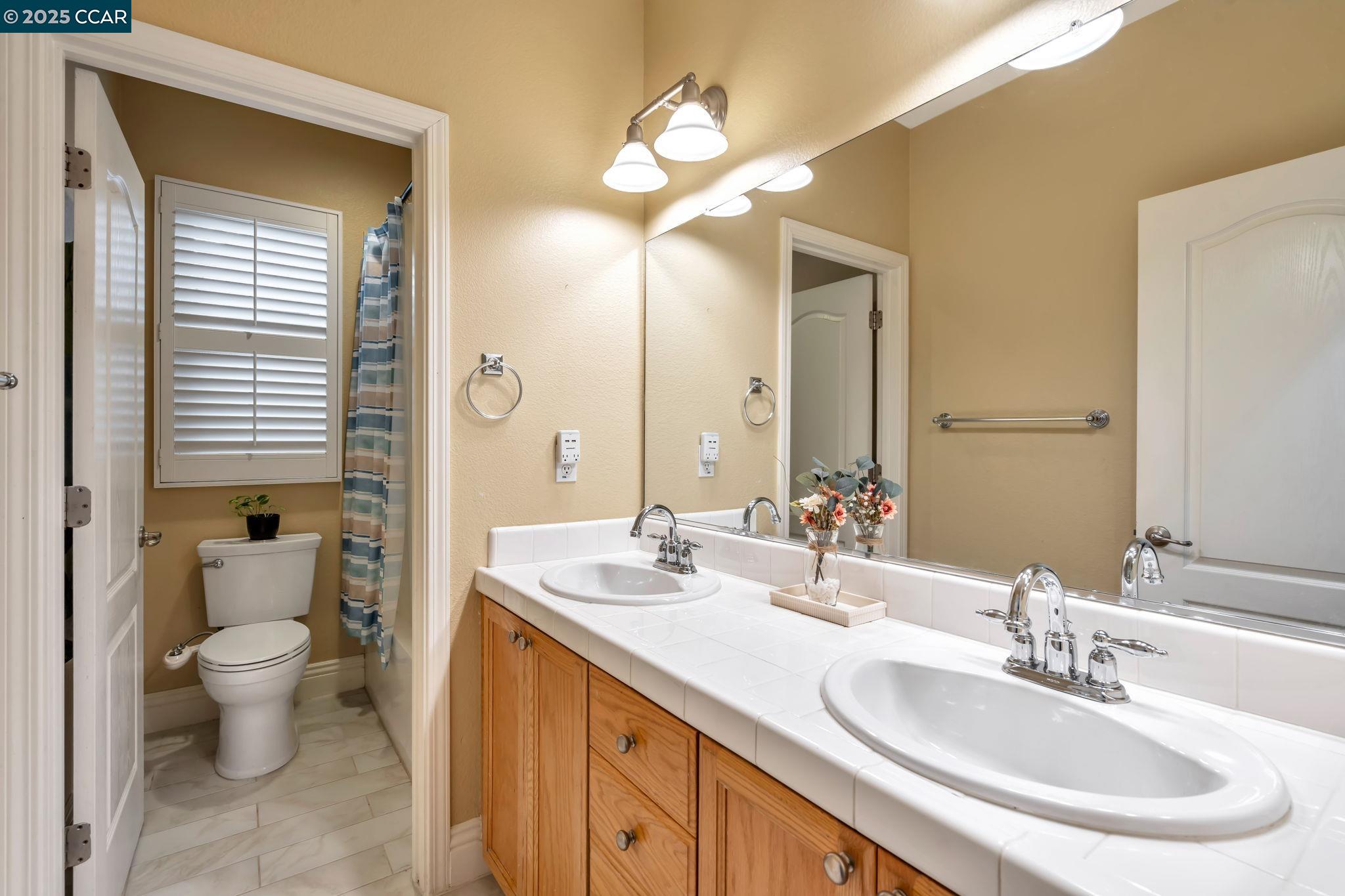 2036 Serra Lane Hercules, CA 94547 - Photo 35 of 60 a bathroom with a toilet a sink and a large mirror