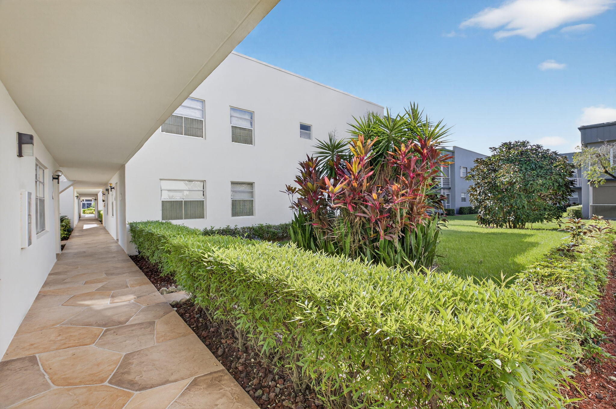 538 Normandy Lane Delray Beach, FL 33484 - Photo 25 of 66 a front view of a house with a garden and yard