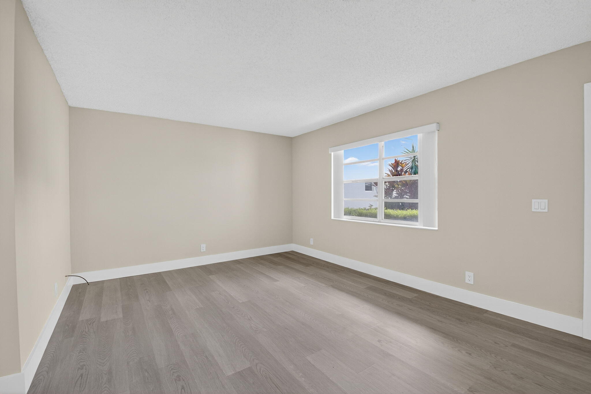 538 Normandy Lane Delray Beach, FL 33484 - Photo 7 of 66 an empty room with wooden floor and window