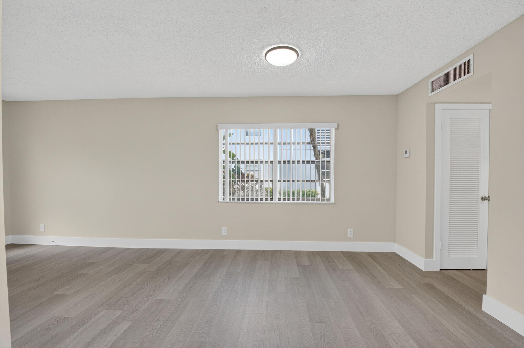 538 Normandy Lane Delray Beach, FL 33484 - Photo 10 of 66 an empty room with wooden floor and windows