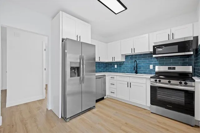 a kitchen with stainless steel appliances granite countertop a stove a refrigerator and a microwave