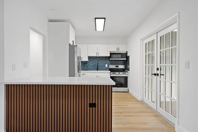 a kitchen with kitchen island a counter top space a stove and cabinets