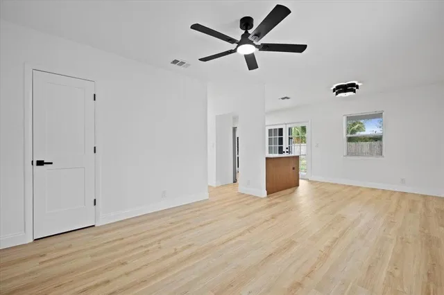 a view of a livingroom with a ceiling fan wooden floor and window