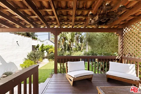 a balcony with wooden benches and wooden fence