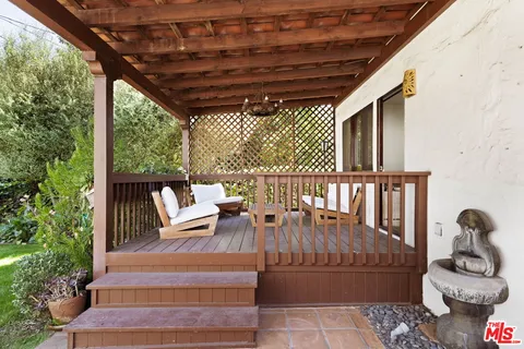 a outdoor space with the couches and dining table with the garden view