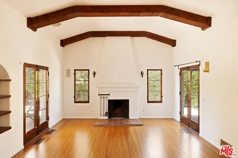 a view of an empty room with exposed radiator and fireplace